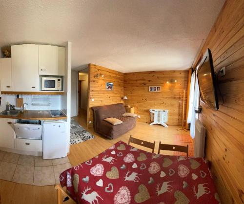 eine Küche und ein Wohnzimmer mit einem Tisch im Zimmer in der Unterkunft Boost Your Immo Les Airelles Risoul 375 in Risoul