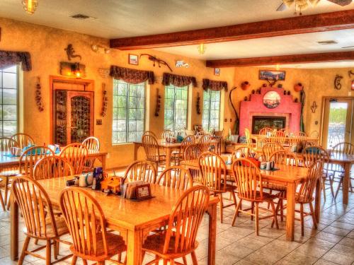 uma grande sala de jantar com mesas e cadeiras de madeira em Stagecoach Trails Guest Ranch em Yucca