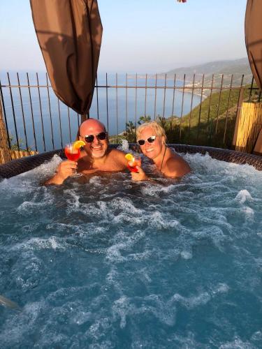 two people in a jacuzzi in a hot tub at B&B Roomantic & Piscina Idromassaggio in Cefalù