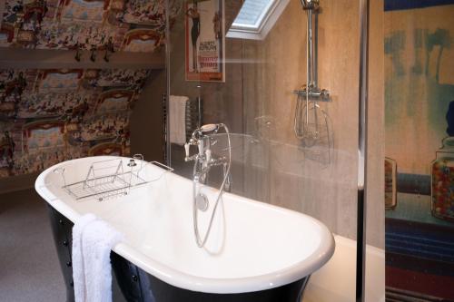 a bath tub in a bathroom with a shower at Brockley Hall Hotel in Saltburn-by-the-Sea