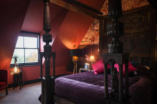 a bedroom with a canopy bed with pink pillows at Brockley Hall Hotel in Saltburn-by-the-Sea