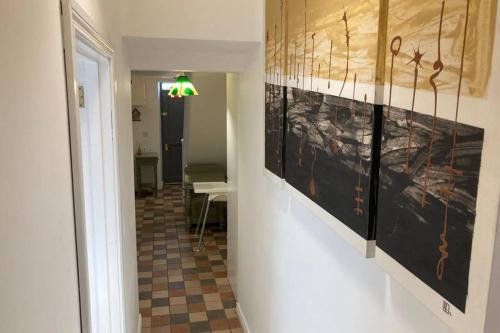 a hallway with paintings on the wall of a room at Temple-Effin Self Catering Holiday Cottage in Whitehead