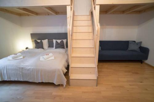 um quarto com uma cama, uma escada e um sofá em Cosy and Spacious Apartment in the heart of Innsbruck em Innsbruck