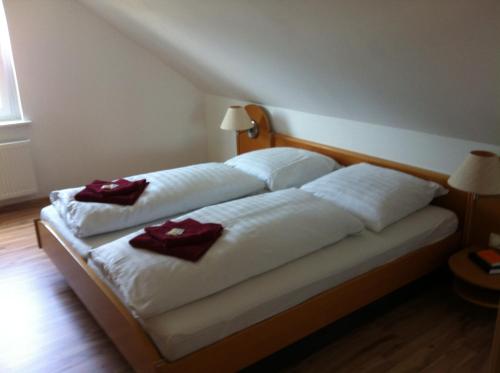 a bedroom with two beds with red towels on them at Hotel & Restaurant Jägerstuben in Ritterhude