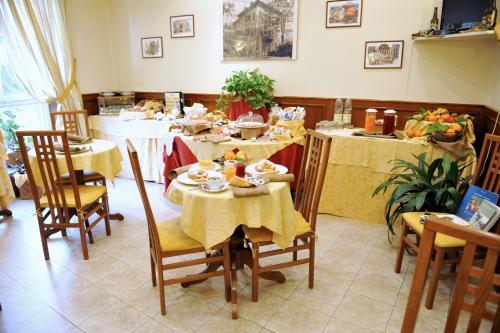 a dining room with tables and chairs with food on them at Albergo Birra in Savignone