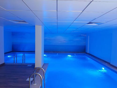 uma piscina com luzes azuis num edifício em Admire Apart' Hotel em Riyadh