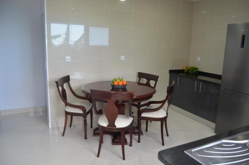 a kitchen with a wooden table with chairs and a refrigerator at Descobrir Madeira in Gaula