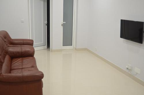a living room with a chair and a television at Descobrir Madeira in Gaula