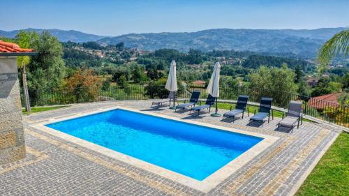 a swimming pool with chairs and umbrellas on a house at Cantinho d'Alcácer in Casal