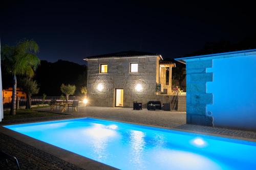 a house with a swimming pool at night at Cantinho d'Alcácer in Casal