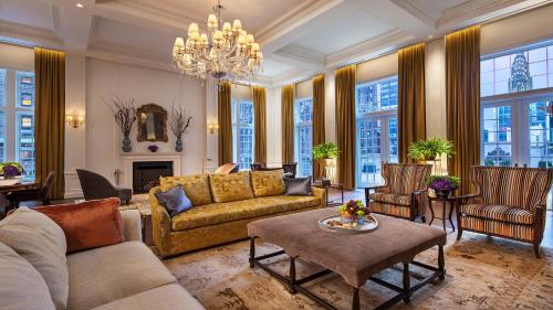 a living room with a couch and a chandelier at InterContinental New York Barclay Hotel by IHG in New York