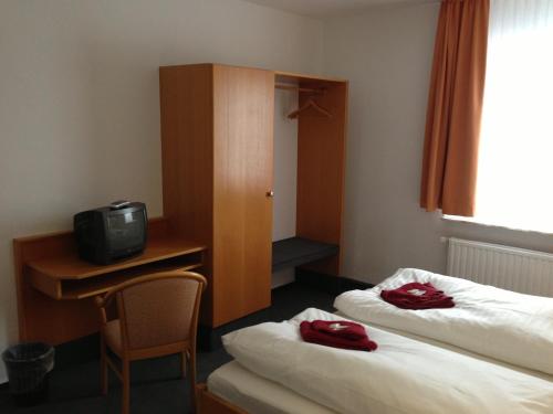 a hotel room with two beds and a television at Hotel & Restaurant Jägerstuben in Ritterhude