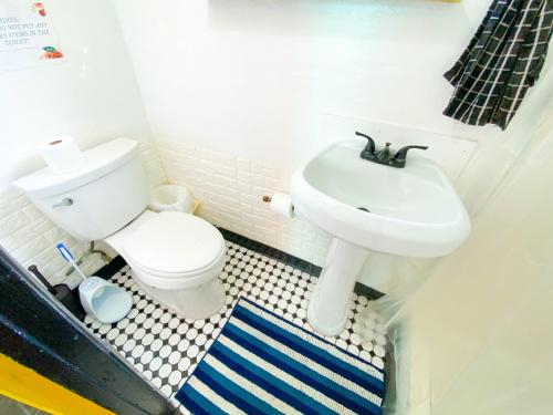 a bathroom with a toilet and a sink at ITH Beach Bungalow Surf Hostel San Diego in San Diego