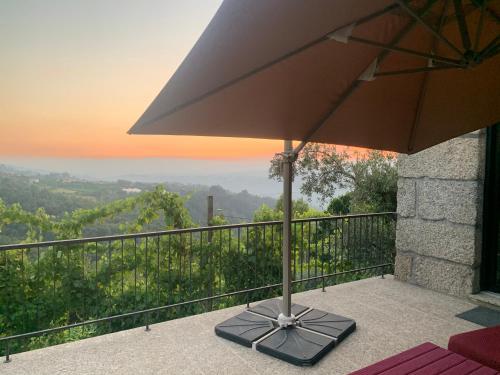 an umbrella sitting on a balcony with a view at Casa AURORA in Amarante