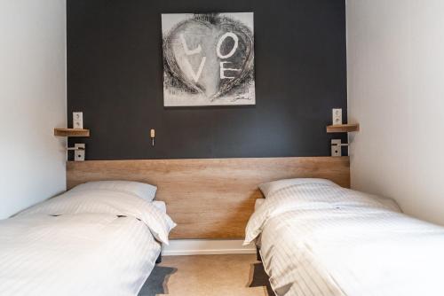 2 camas en un dormitorio con paredes negras en New Bay, en Callantsoog