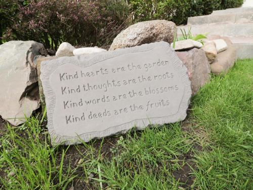 a sign sitting on the grass next to some rocks at Tarnacrye in Annan