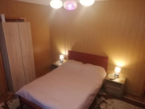 a small bedroom with a bed and two lights on the wall at Casa Bucur in Tîrgu Ocna