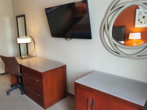a hotel room with a desk and a mirror at Hotel San Francisco Leon in León