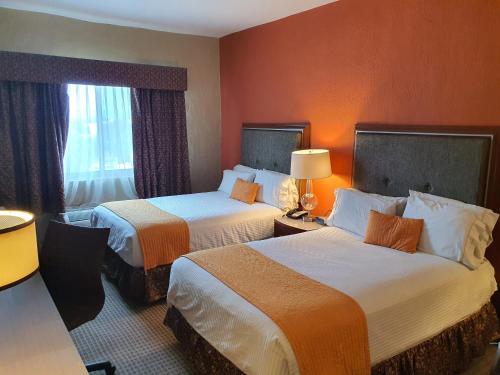 um quarto de hotel com duas camas e uma janela em Hotel San Francisco Leon em León