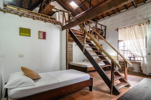 a bedroom with a bed and a wooden staircase at Giron Chill Out Hotel Boutique in Girón