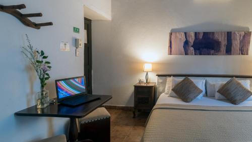 a room with a bed with a laptop on a desk at Giron Chill Out Hotel Boutique in Girón