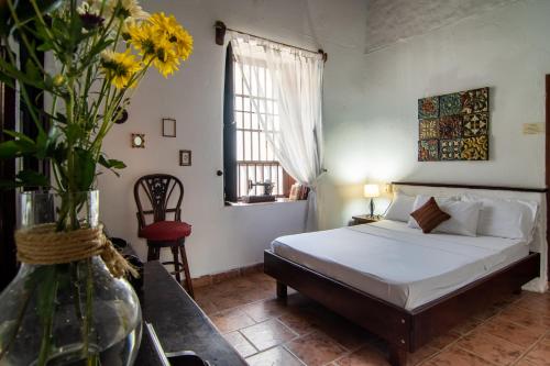 a bedroom with a bed and a vase with flowers at Giron Chill Out Hotel Boutique in Girón