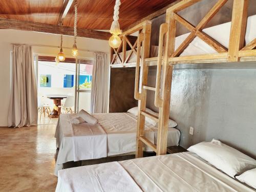 a bedroom with two bunk beds and a piano at Pousada Primeira Praia Suítes in Morro de São Paulo