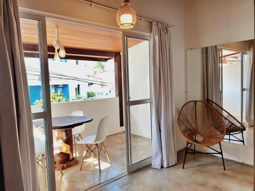 a dining room with a table and chairs and a window at Pousada Primeira Praia Suítes in Morro de São Paulo