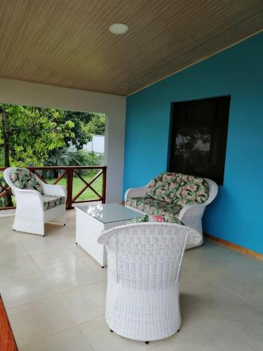 a living room with two chairs and a table and a tv at Tropical Housing by El Rodeo - Puerto Jimenez Centro in Puerto Jiménez