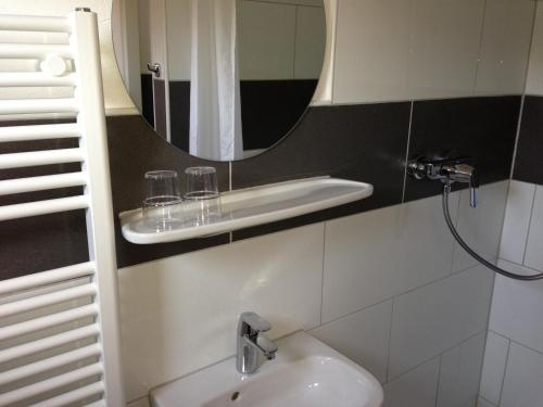 a bathroom with a sink and a mirror at Hotel & Restaurant Jägerstuben in Ritterhude