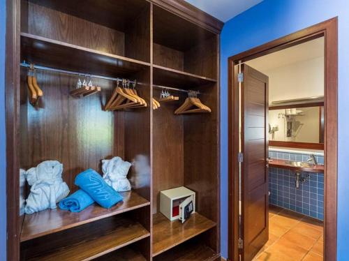 łazienka z drewnianymi półkami, ręcznikami i lustrem w obiekcie Villa Finesse 1 - Lovely 3 bedroom villa - Great pool area - Perfect for families w Son Bou