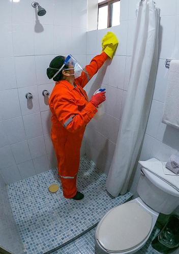 a person in an orange jumpsuit is in a bathroom at Best Western Hotel Madan in Villahermosa