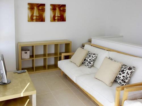 una sala de estar con un sofá blanco con almohadas en Villa De La Brisa - Four Bedroom Villa Sleeps 10 with spectacular sea views en Son Bou