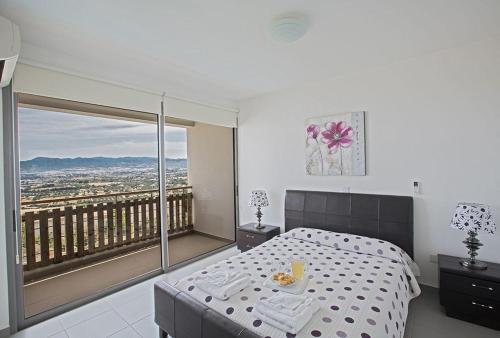 una camera con letto e un balcone con vista di Villa Tavrou Dyo - Luxury 3 Bedroom Latchi Villa with Private Pool - Stunning Sea Views a Neo Chorio