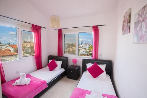 duas camas num quarto com rosa e branco em Villa Kavo Sunshine - Beautiful 3 Bedroom Protaras Villa with Private Pool - Close to the Beach em Protaras