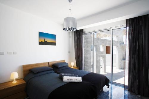 um quarto com uma cama e uma grande janela em Luxury Cyprus Villa Sea View Villa Private Pool Sea View 1 BDR Paphos em Paphos