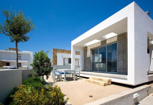 uma casa moderna com um pátio e uma sala de jantar em Luxury Cyprus Villa Sea View Villa Private Pool Sea View 1 BDR Paphos em Paphos