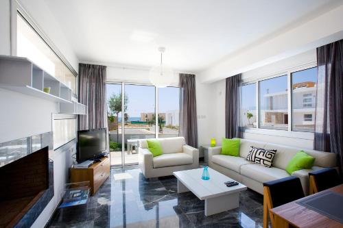uma sala de estar com um sofá e uma televisão em Luxury Cyprus Villa Sea View Villa Private Pool Sea View 1 BDR Paphos em Paphos