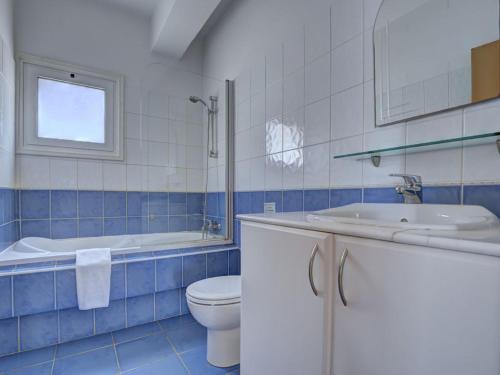 a blue and white bathroom with a toilet and a sink at Villa Oforo Selene - Stunning 4 Bedroom Villa - By Fig Tree Bay Beach - Sea Views in Protaras