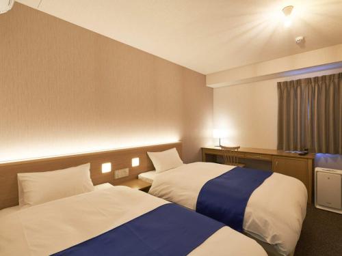 a hotel room with two beds and a window at Hotel Meriken Port Kobe Motomachi in Kobe