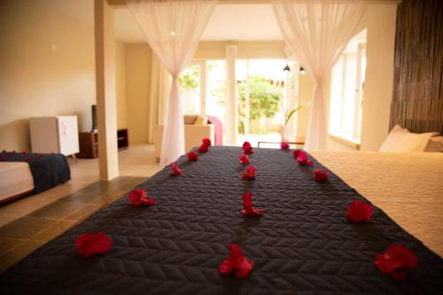 a group of red roses on a bed in a room at Pousada Vila Sagui in Maragogi