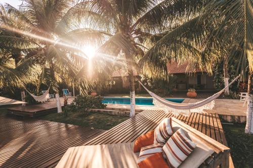 a hammock in front of a resort with palm trees at Pousada Vila Sagui in Maragogi