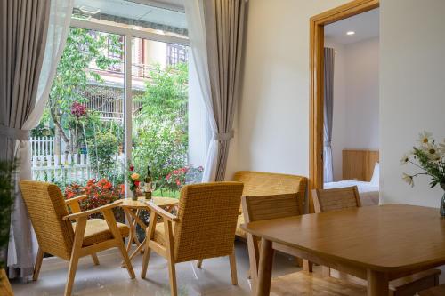 a dining room with a table and chairs and a window at Đỗ Gia Bảo Villa in Da Lat