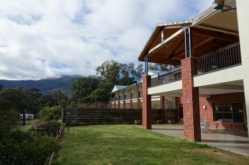 a building with a grassy yard in front of it at Elkanah Lodge and Conference Centre in Marysville