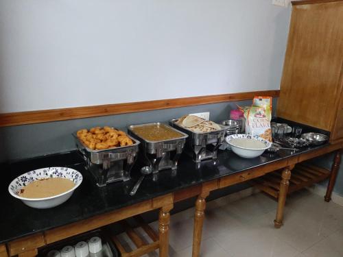 a buffet with bowls of food on a table at The Boat Jetty Bungalow in Cochin