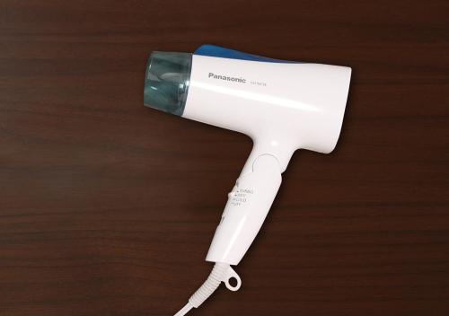 a hair dryer sitting on top of a wooden table at Hotel Trend Fukuyama Ekimae in Fukuyama