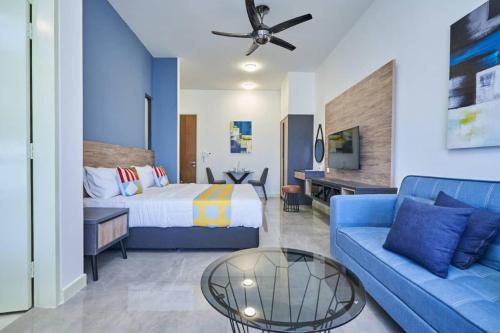 um quarto de hotel com uma cama e um sofá azul em BotakCuteHomestay@Imperio Residence em Malaca