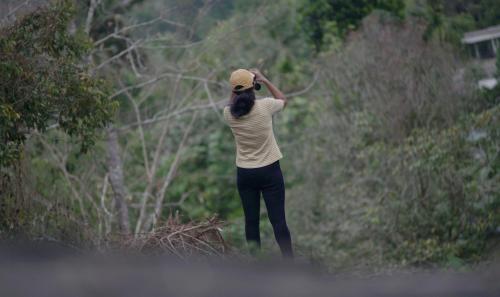 a woman wearing a hat standing in a field at Beyond Eco Living in Munnar