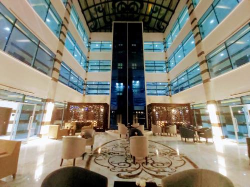 um grande átrio com mesas e cadeiras num edifício em Admire Apart' Hotel em Riyadh