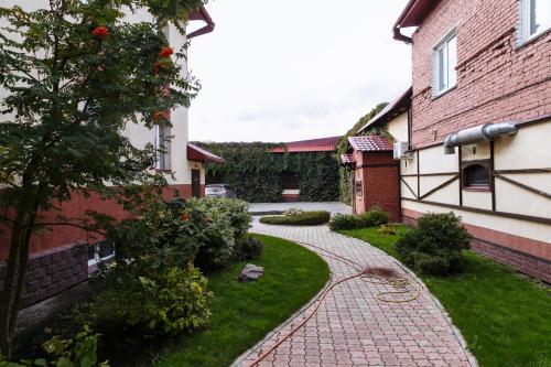 einen Backsteinsteg in einem Hof neben einem Haus in der Unterkunft Hotel Na starom meste in Bijsk